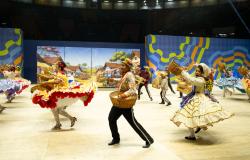 Apresentação de quadrilha em espaço próprio para o arraial de BH, bailarinos dançam vestidos com roupas características. 