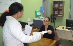 Profissional da Saúde entrega documentos de consulta à paciente