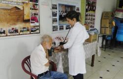 Profissional da saúde medindo pressão de um senhor em Centro de Saúde