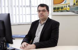 Diretor de Planejamento, Gestão e Finanças do Hospital Odilon Behrens - Guilherme José Antonini Barbosa, posa em uma fotografia em local fechado com camisa tom de marrom