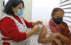 Enfermeira aplicando vacina em uma senhora