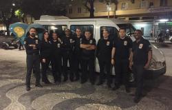 Nove membros da equipe da Guarda Municipal em frente à van, no local em que realizaram operação conjunta de fiscalização, durante a noite. 