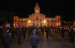 Foto noturna na praça da estação, com o prédio do Museu de Artes e Ofícios ao fundo e guardas municipais enfileirados