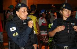 Duas guardas municipais em evento carnavalesco realizando ação de conscientização contra assédio