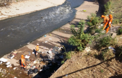 Funcionários da SLU limpando o leito do Ribeirão Arrudas