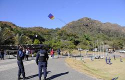 Dois guardas municipais no Parque as Mangabeiras, um deles está soltando pipa; mais de seis pessoas soltam pipa também, durante o dia. 