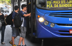 Dois estudantes pegam ônibus, durante o dia.