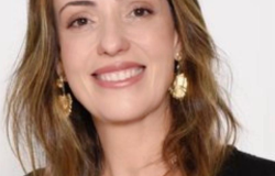 Diretora Jurídica da Urbel - Glória Consuelo Coelho de Paiva, posa em uma fotografia apenas de rosto em local fechado.