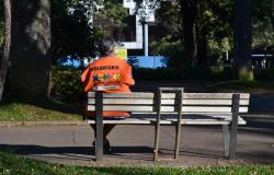 Voluntária sentada em um banco de praça