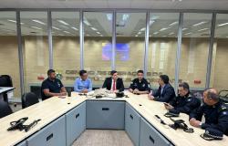 Gestores reunidos ao redor de uma grande mesa em formato de U em uma sala de reuniões, tendo ao fundo divisórias de vidro com a inscrição "Centro de Operações da Prefeitura de Belo Horizonte"