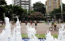 À frente, fonte de água da Praça da Savassi em funcionamento. Ao centro, ciclistas pedalam no cruzamento das avenidas Cristóvão Colombo e Getúlio Vargas, fechado no domingo. Ao fundo, árvores e prédios que cercam a praça da Savassi.