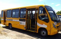 Ônibus coletivo de transporte suplementar parado e de portas abertas durante o dia.