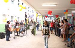 Banda de forró com três integrantes se apresenta para mais de dez pessoas no Centro Pop Leste durante o dia.