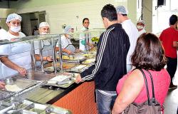 Dois cidadãos passam a bandeja e são servidos por funcionários do Restaurante Popular do Barreiro durante o dia.