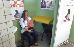 Mulher amamenta com filho no colo em Unidade de coleta de leite humano no Centro de Saúde Venda Nova