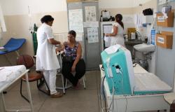 Enfermeira mede a pressão de paciente em laboratório do SUS