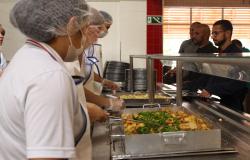 Na imagem, aparecem funcionários do Restaurante popular de costas servido refeição aos cidadãos.