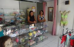 Duas vendedoras em loja de roupas.