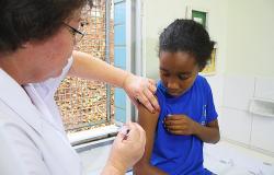 Técnica de saúde aplica vacina contra HPV em garota pré-adolescente. 