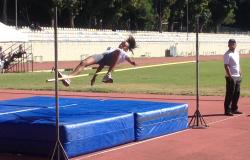 Estudante e atleta feminina pratica salto olímpico durante o dia