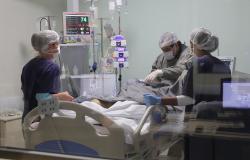 Equipe de três profissionais de saúde do CTI do Hospital Municipal Célio de Castro, conhecido como Hospital do Barreiro, atende a paciente em um dos novos leitos implantados. 