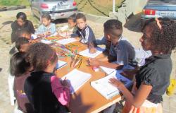 Oito crianças participam de oficina de artesanato no estacionamento Residencial Várzea da Palma, na Pampulha.