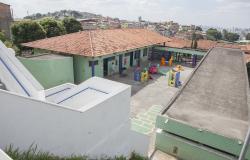 Pátio de escola municipal com brinquedos infantis coloridos.