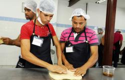 Os irmãos Joseílson e João Ricardo abrindo uma massa de pão na mesa da Padaria Pão Escola, onde fazem curso profissionalizante. 