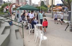 Cidadãos realizam exame em estande do Projeto caminhar durante o dia.