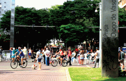 Mais de dez pessoas andam de bicicleta em rua interditada na Savassi durante o dia. 