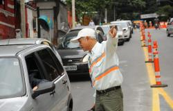 Agente de trânsito da BHTrans dá orientações a motoristas em rua com sinalização. 