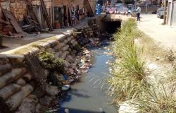 Córrego Várzea da Palma com lixo nas beiradas.