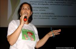 Mulher com camiseta em defesa do meio ambiente realiza palestra com microfone.