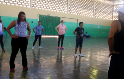 Cerca de cinco alunos praticam aulas gratuitas de dança em quadra escolar.