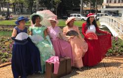 Cinco idosas usando roupas de época em um parque municipal da cidade