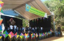 Mais de dez pessoas se apresentam em palco coberto ao ar livre; no alto do palco, uma faixa com os dizeres "Festival Regionalizado 2017"