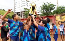 Cerca de seis jogadores mirins, dentre eles alunos do programa Esporte Esperança, seguram taça da categoria infantil da Copa Centenário.