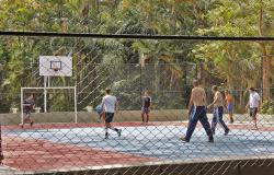 Sete homens jogam basquete em quadra no Parque