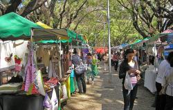 Cerca de cinco homens e mulheres passeiam nas mais de dez barraquinhas da feira de artesanato da avenida Bernardo Monteiro. 