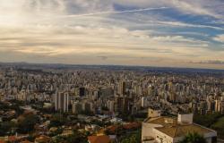 Foto aérea de cidade de Belo Horizonte, com muitos prédios e céu azul com nuvens, durante o dia.