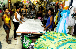 Sete mulheres organizando fantasias da escola de samba Acadêmicos de Venda Nova