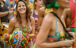 Foliões em trajes coloridos pulando carnaval.