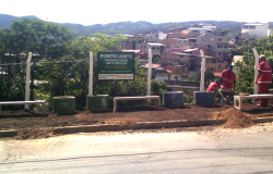 Três funcionários da slu realizando a limpeza de terreno na Vila Pinho