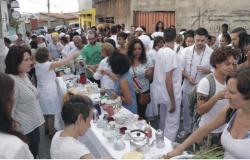 Mais de trinta pessoas de branco em torno de uma mesa da comunidade quilombola Manzo. 