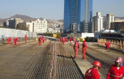Cerca de 14 funcionários trabalham na construção do Viaduto Leste, na Lagoinha, ao fundo, prédios e cidade.