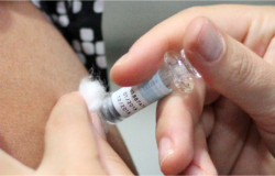 Um profissional da saúde aplica vacina contra gripe em um servidor municipal. 