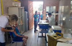 Dois profissionais da saúde vacinando crianças da Rede Municipal de Ensino