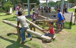 Crianças brincam em gangorra em Parque da cidade