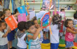 Crianças de 2 ou 3 anos brincam com livros em Umei