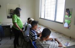 Quatro jovens e uma profissional do CRAS Taquaril fazendo artesanatos